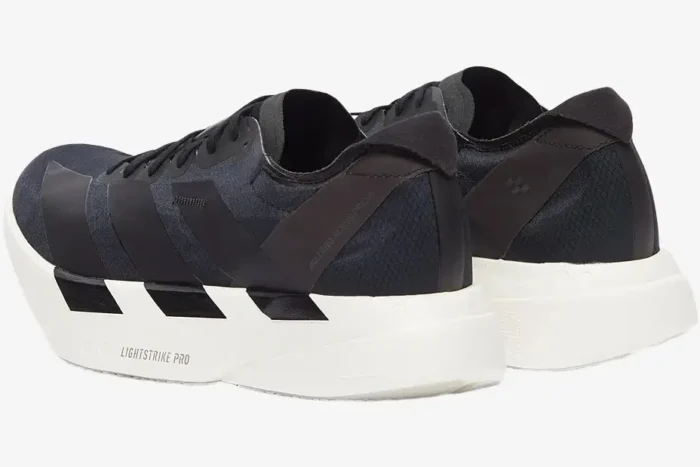 Rear perspective of Adidas Adizero Adios Pro 4 running shoes in black and white with Lightstrike Pro foam. - SKU JR6369