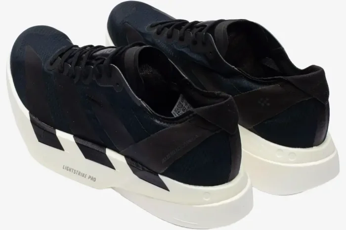 Rear-side view of black and white Adidas Adizero Adios Pro 4 running shoes with thick white midsoles. - SKU JR6369