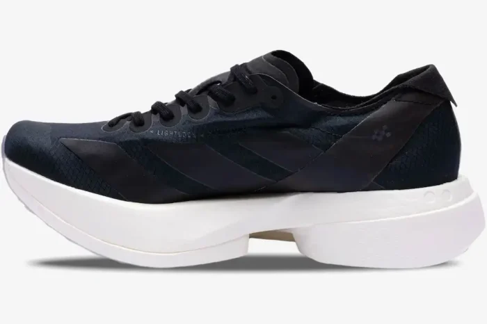 Side profile of the Adidas Adizero Adios Pro 4 running shoe in black and white with a thick midsole. - SKU JR6369