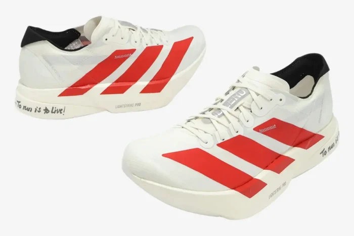 White Adidas Adizero Adios Pro 4 running shoes with red stripes and 'To run is to live' text on the heel. - SKU JR6363