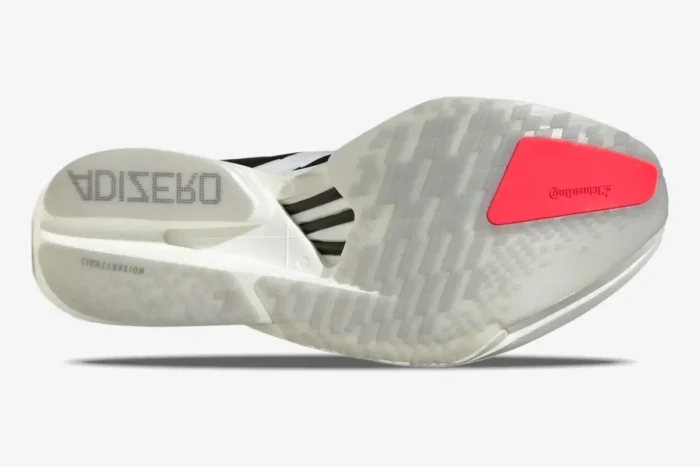 Bottom view of Adidas Adizero Adios Pro 4 running shoe outsole in white with a red Continental rubber patch. - SKU JR1094