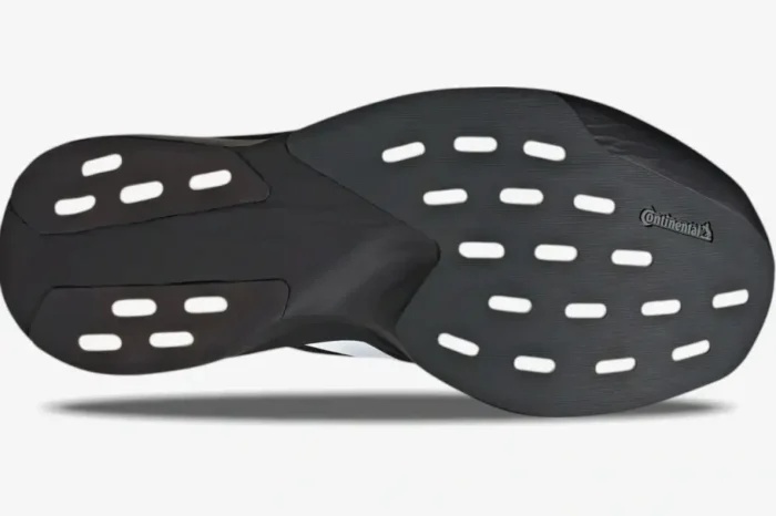 Bottom view of the Adidas Adizero Evo SL in Core Black, showing the Continental rubber outsole and white cutouts. - SKU JP7149