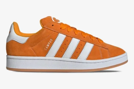 Side view of Adidas Campus 00s sneakers in amber tint orange suede with white stripes and sole. - SKU ID1436
