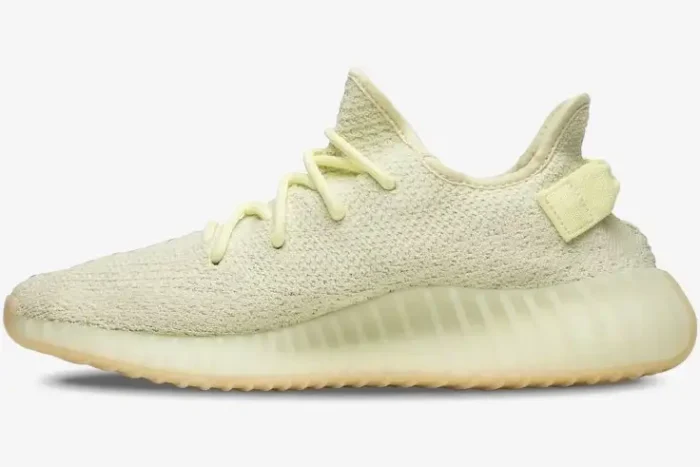 Side profile view of the Adidas Yeezy Boost 350 V2 Butter sneaker in a pale yellow cream color. - SKU F36980