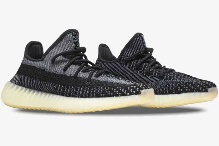 Side profile view of Adidas Yeezy 350 V2 Carbon sneakers with black and grey knit uppers and cream midsoles. - SKU FZ5000