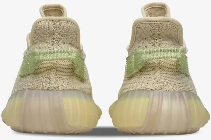 Rear view of Adidas Yeezy 350 V2 Flax sneakers showing the beige Primeknit upper and light green heel tabs. - SKU FX9028