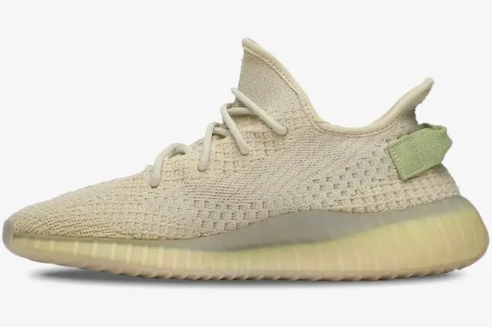 Side profile of Adidas Yeezy 350 V2 Flax sneakers in light beige with a green heel tab. - SKU FX9028