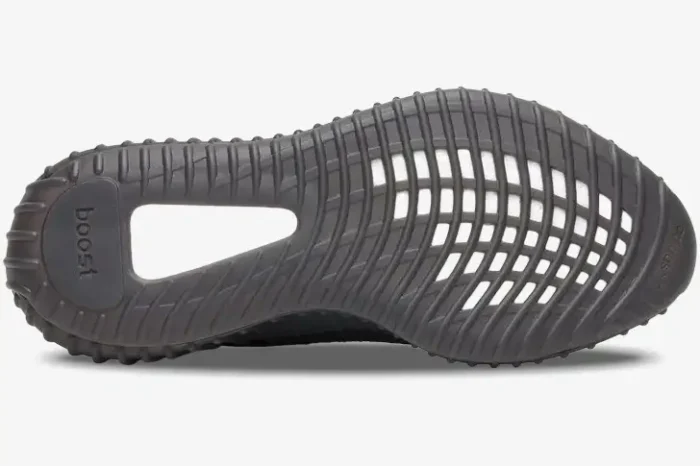 Bottom view of an Adidas Yeezy Boost 350 V2 Black Red showing the dark grey textured outsole and white Boost foam. - SKU CP9652