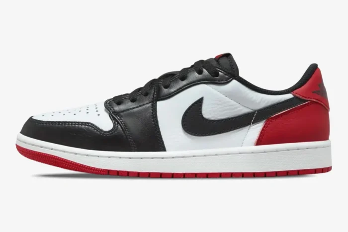 Side profile of Air Jordan 1 Low Black Toe sneakers in white, black, and red leather with a red outsole. - SKU 553558-116