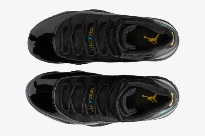 Top-down view of black Air Jordan 11 Retro Gamma Blue sneakers with yellow Jumpman logos on the insoles. - SKU 378037-006