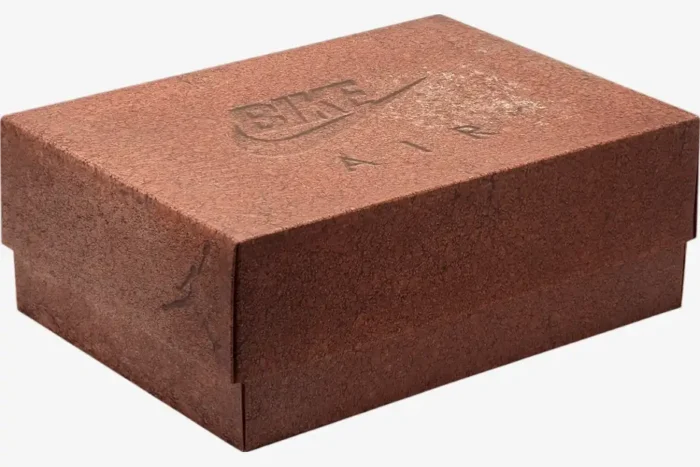 Three-quarter view of the reddish-brown textured shoebox for Air Jordan 4 x Nigel Sylvester Bike Air. - SKU HF4340-800