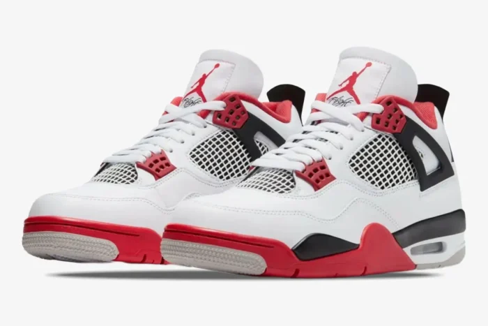 A pair of Air Jordan 4 Retro Fire Red sneakers in white, red, and black, shown from a three-quarter front angle. - SKU DC7770-160