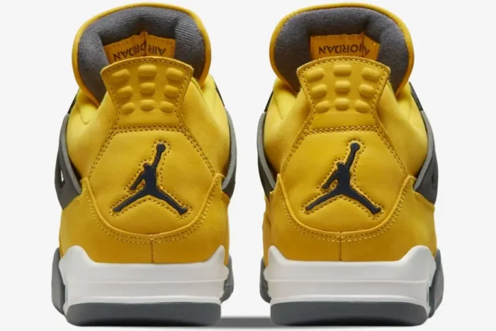 Rear view of yellow Air Jordan 4 Retro Lightning sneakers with black Jumpman logo on the heel. - SKU CT8527-700