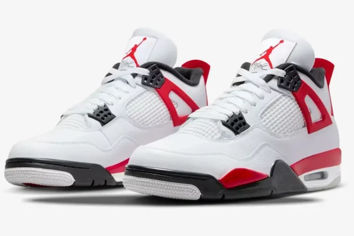 Three-quarter front view of Air Jordan 4 Retro Red Cement sneakers in white with red speckled accents. - SKU DH6927-161