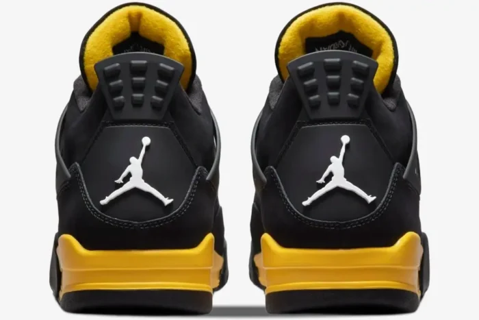 Rear view of Air Jordan 4 Retro Thunder sneakers in black and yellow with white Jumpman logos. - SKU DH6927-017