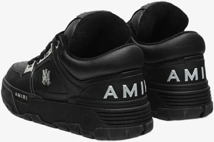 Black leather Amiri MA-1 sneakers with metallic silver logo details, shown from a rear three-quarter angle. - SKU AMFOSR1152-001