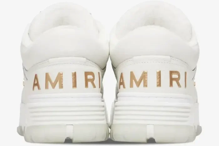 Rear view of Amiri MA-1 Metallic White Gold Sneakers featuring gold logo lettering on the white leather heels. - SKU 252886M237010