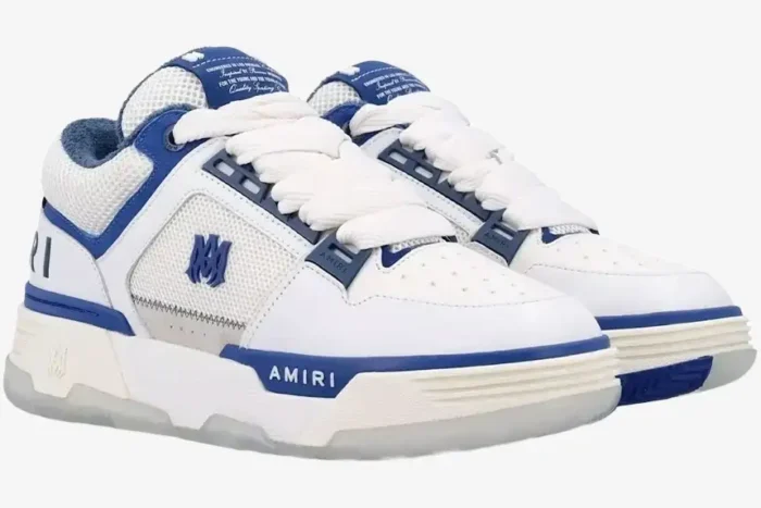 A pair of white and blue Amiri MA-1 sneakers displayed from a three-quarter side perspective. - SKU AMFOSR1048454