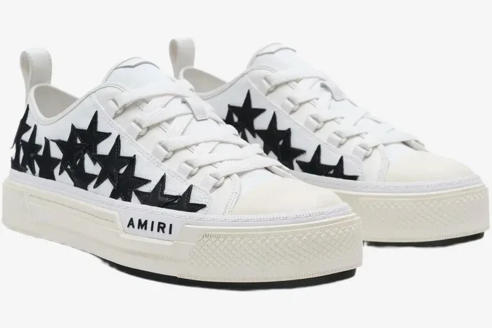 Amiri Stars Court Low-Top Sneakers in white with black star patches, three-quarter side view. - SKU AMFOSR1179-111