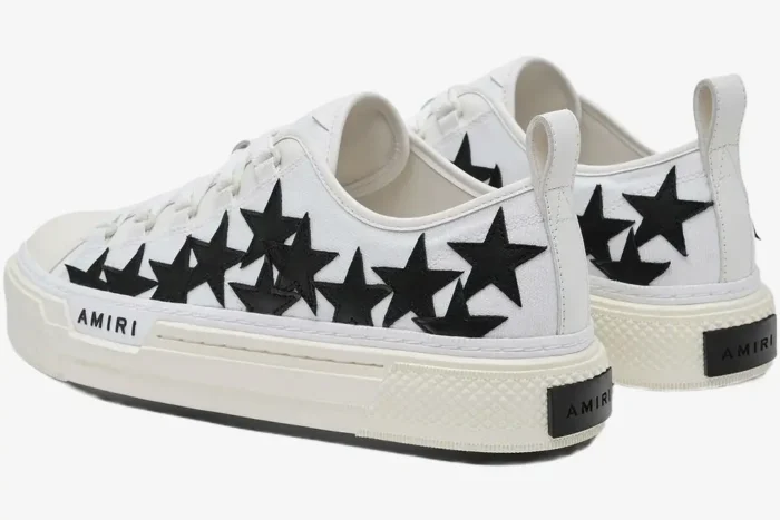 Amiri Stars Court low-top sneakers in white and black, rear three-quarter view showing star patches and platform sole. - SKU AMFOSR1179-111