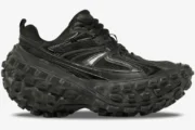 Side profile of the Balenciaga Defender Chunky Sneaker in black, featuring a massive tire-tread platform sole. - SKU 685613W2RA61000