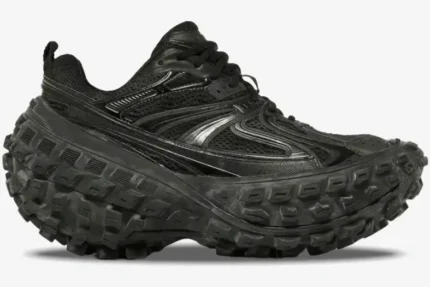 Side profile of the Balenciaga Defender Chunky Sneaker in black, featuring a massive tire-tread platform sole. - SKU 685613W2RA61000