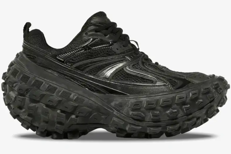 balenciaga-defender-chunky-sneaker-black-side-685613w2ra61000-546-755 Side profile of the Balenciaga Defender Chunky Sneaker in black, featuring a massive tire-tread platform sole. - SKU 685613W2RA61000