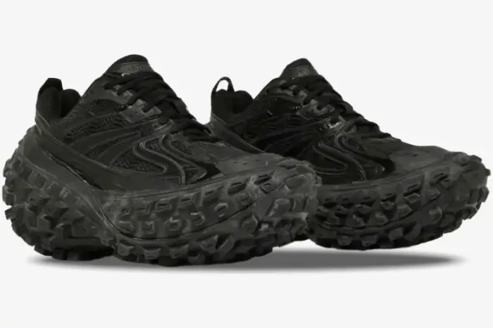 Side view of black Balenciaga Defender chunky sneakers with exaggerated tire-tread soles. - SKU 685613W2RA61000