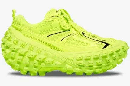 Side profile of a Balenciaga Defender sneaker in fluo yellow featuring an oversized tire-tread sole. - SKU 685613W2RAB7510