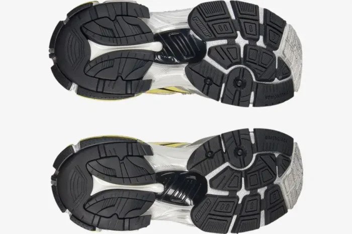 Bottom view of Balenciaga Runner 2 Distressed Mesh sneakers in yellow and silver showing textured black outsoles. - SKU 779066W3RXP9710