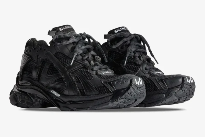 Three-quarter view of Balenciaga Runner all black distressed sneakers featuring mesh panels and chunky soles. - SKU 772774W3RBT1000