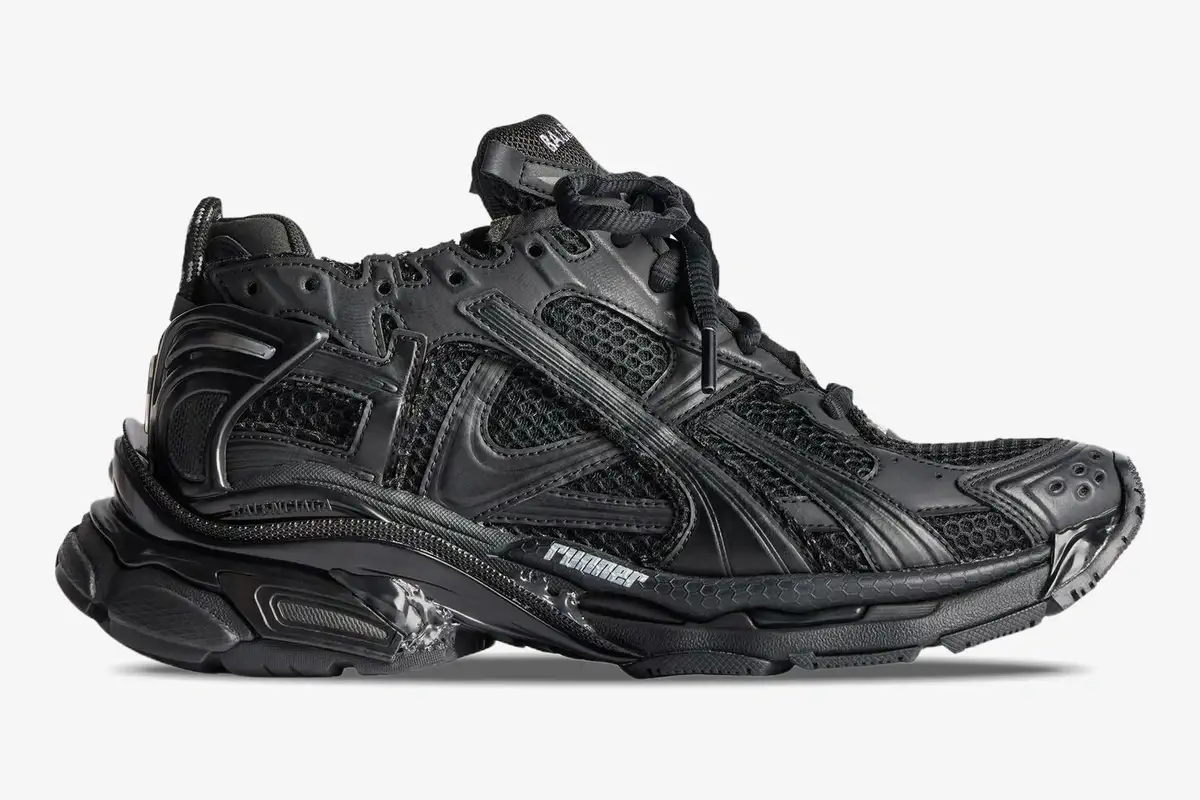 balenciaga-runner-all-black-distressed-side-view-772774w3rbt1000-495-042 Side profile of a Balenciaga Runner All Black Distressed Sneaker with mesh panels and chunky sole. - SKU 772774W3RBT1000
