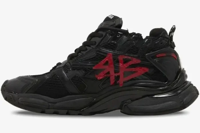 Side profile of Balenciaga Runner Graffiti sneakers in black with red logo and distressed finish. - SKU 677403W3RBQ1060