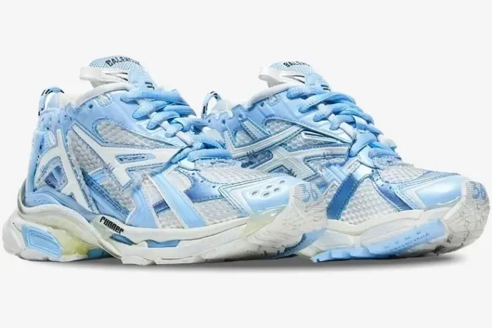 A pair of Balenciaga Runner sneakers in light blue and white, shown from a three-quarter angle. - SKU 677402W3RB29744