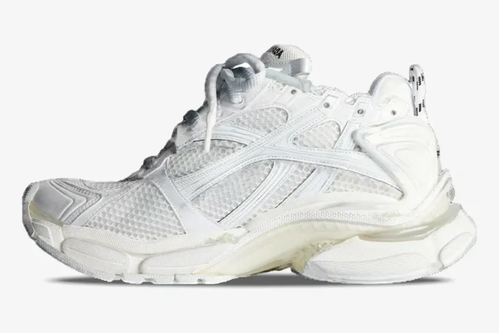 Side profile of white Balenciaga Runner sneakers with mesh panels and a chunky layered sole. - SKU 772774W3RMU9000