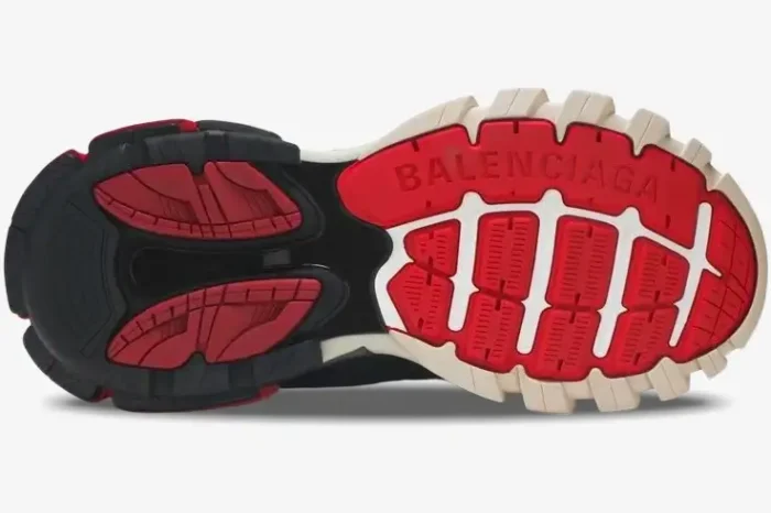 Bottom sole view of Balenciaga Track sneakers in black, grey, and red with branded tread pattern. - SKU 542023W1GB61002