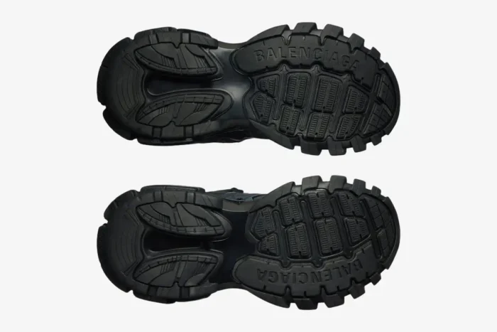 Bottom view of black Balenciaga Track sneakers featuring chunky tread outsoles and branding. - SKU 542023W1GB11000