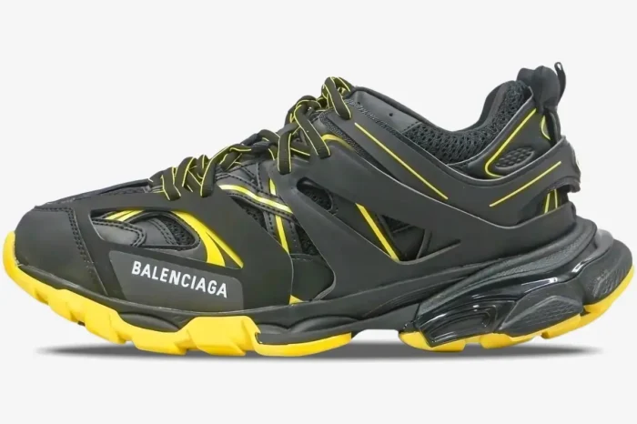 Side profile of a Balenciaga Track sneaker in black and yellow with a layered design and chunky sole. - SKU 542023W3AC11070