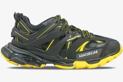Side view of a Balenciaga Track sneaker featuring a black multi-layered design with yellow accents. - SKU 542023W3AC11070