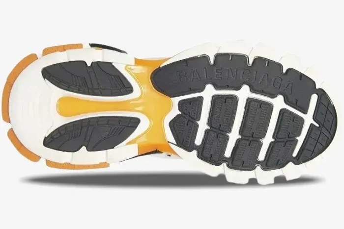 Bottom sole view of Balenciaga Track Sneaker in white, orange, and black with intricate tread pattern. - SKU 542023W1GB19059