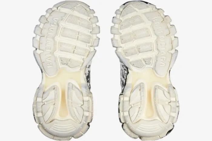 Bottom view of Balenciaga Track sneakers in white and black graffiti print showing the textured outsoles. - SKU 542023W3RRA9010