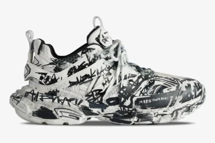 Side profile of a Balenciaga Track sneaker in white with black graffiti print all over. - SKU 542023W3RRA9010