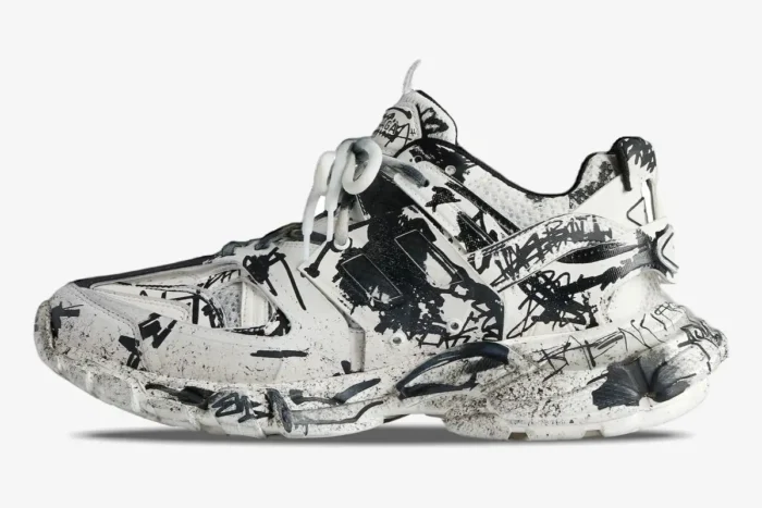Side profile of a white Balenciaga Track sneaker with black graffiti print and a chunky sole. - SKU 542023W3RRA9010