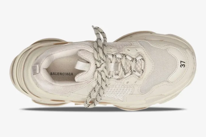 Top-down view of a beige Balenciaga Triple S sneaker featuring white and black patterned laces. - SKU 524039W2FW19700