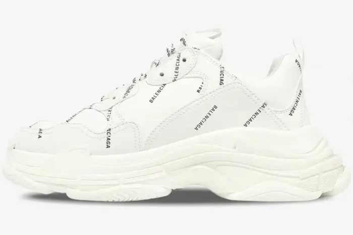 Side profile of a white Balenciaga Triple S sneaker with black all-over logo print and chunky sole. - SKU 536737W2FA19010