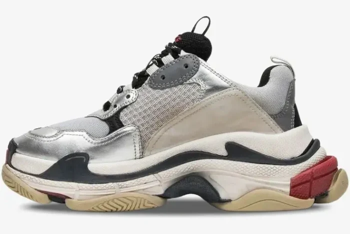 Side profile of Balenciaga Triple S sneakers in silver, black, and metallic grey with a chunky sole. - SKU 524039W09O68165