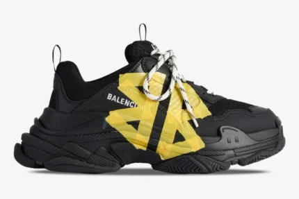 Balenciaga Triple S Tape Type sneaker in black and yellow, side profile view showing chunky sole and tape details. - SKU 536737WTRST1070