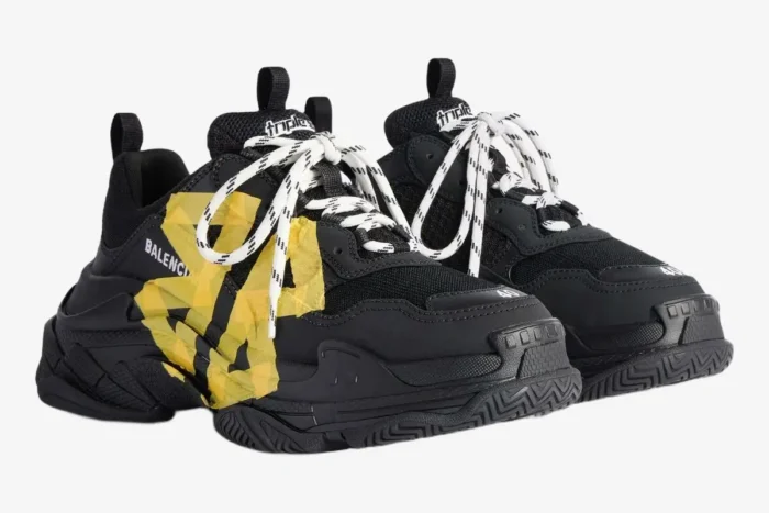 Balenciaga Triple S Tape Type black sneakers with yellow tape detail, three-quarter view. - SKU 536737WTRST1070