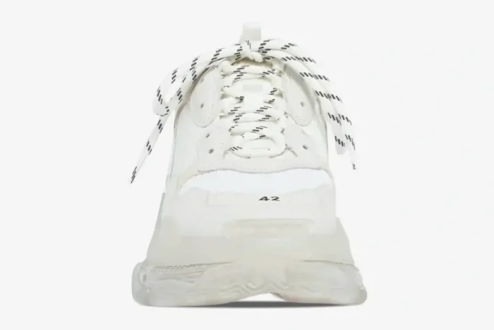 Front view of a white Balenciaga Triple S sneaker with a chunky clear sole and striped laces. - SKU 544351W2FB19000
