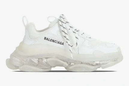 Side profile of a white Balenciaga Triple S sneaker with a chunky clear sole and black logo. - SKU 544351W2FB19000